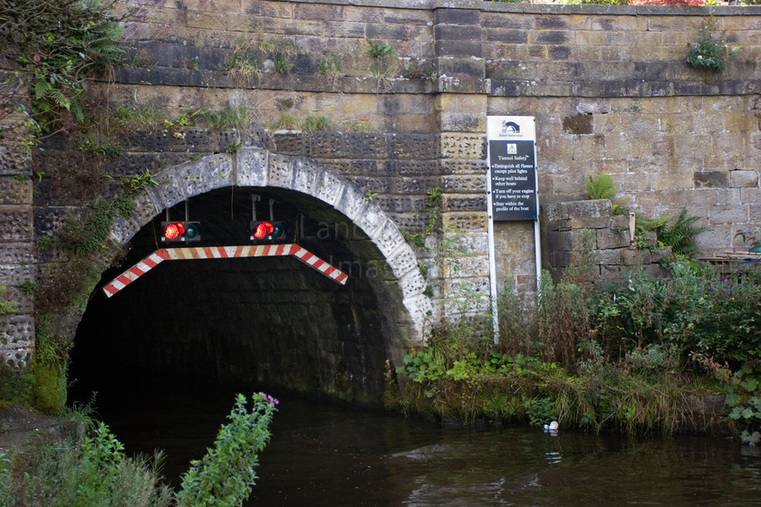 DCP1228 
 Entrance to Fouldidge tunnel at Foulridge Wharf. The tunnel was originally opened in 1796 and is about a mile long. 
 Keywords: Foulridge, Colne, Leeds, Liverpool, Canal, Lancashire, Lancs, North, West, Northwest, England, UK, Britain, Europe, wharf, tunnel, stop, traffic, light, no, entry, entrance, sign, info, information, industrial, heritage, history, water, horizontal, DCP1227