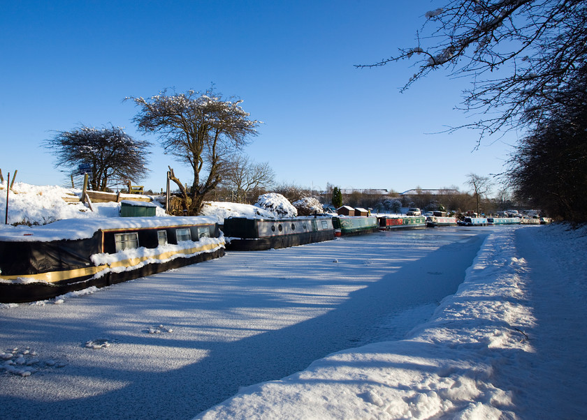 DCP1732 
 Snow covered Leeds Liverpool Canal at Adlington in Lancashire 
 Keywords: Adlington, Leeds and Liverpool, Canal, waterway, season, winter, snow, cold, ice, freeze, frozen, tow, path, towpath, narrow, boat, boats, barge, barges, transport, transportation, tree, moored, shadow, shadows, blue, sky, Lancashire, Lancs, Northwest, North, West, England, UK, Britain, Europe, DCP1732