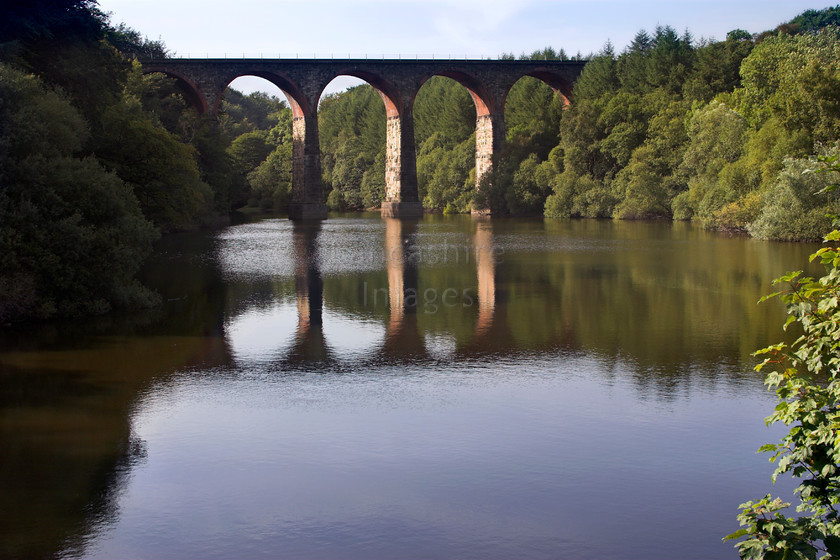 DCP0966 
 Railway viaduct reflected in the waters of Wayoh reservoir near Edgworth and Entwistle 
 Keywords: Edgworth, Entwistle, Wayoh, reservoir, Lancashire, Lancs, North, West, Northwest, England, UK, Britain, Europe, railway, viaduct, transport, transportation, rail, arch, archway, bridge, brick, architecture, water, reflect, reflection, reflected, mirror, image, mirrored, ripple, side, light, wood, wooded, woodland, industry, industrial, natural, nature, manmade, man, made, blue, sky, horizontal, DCP0966