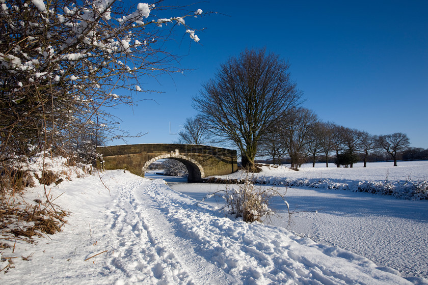 DCP1695 
 Bridge 66 on the Leeds and Liverpool Canal in winter 
 Keywords: Adlington, Leeds and Liverpool, Canal, waterway, bridge, arch, archway, curve, curving, season, winter, snow, cold, ice, freeze, frozen, tow, path, blue, sky, Lancashire, Lancs, Northwest, North, West, England, UK, Britain, Europe, DCP1695